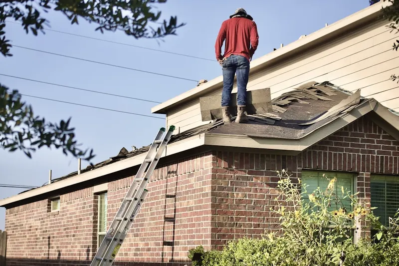 Professional roofer working on a residential roof in Beeville